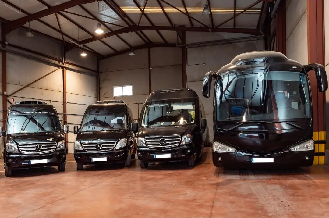 Tres minibuses y una guagua de Autobuses La Palmita aparcados en una de nuestras naves garaje.